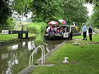 A group of people on the Bruce Trust barge called "Hannah", entering a lock on the Kennet and Avon canal