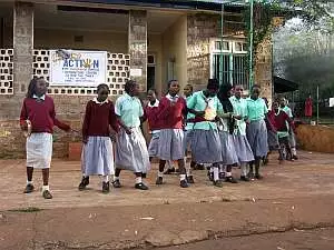 A group of children give a musical welcome outside the Interim Care Center in Thika