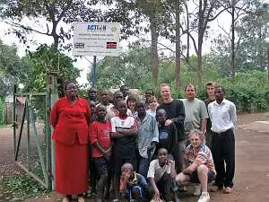 A group of around twenty Rotary members, AfCiC staff and children standing outside the Interim Care Centre