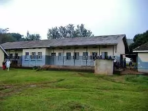 A brick building with corrugated roof, painted cream and blue