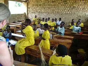 School children, many of them in bright yellow uniforms, in their classroom at Champona school